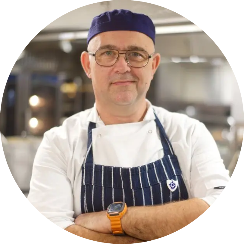 A picture of a man in a striped apron and chef’s hat