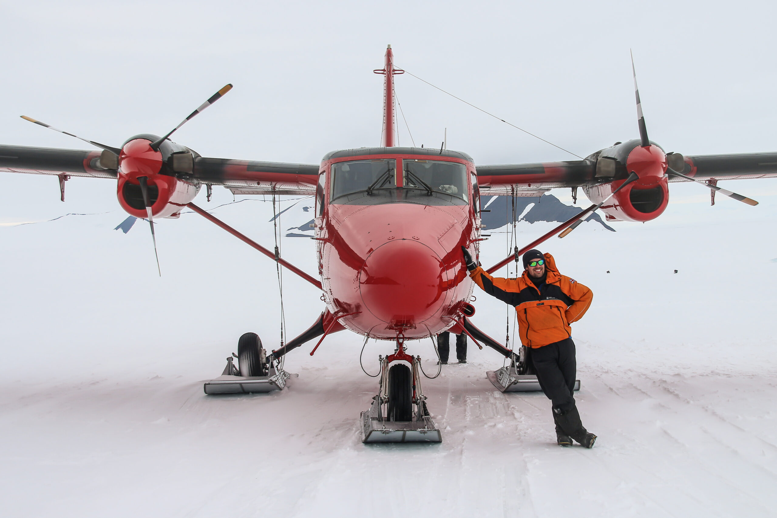 A man stood next to a red plane