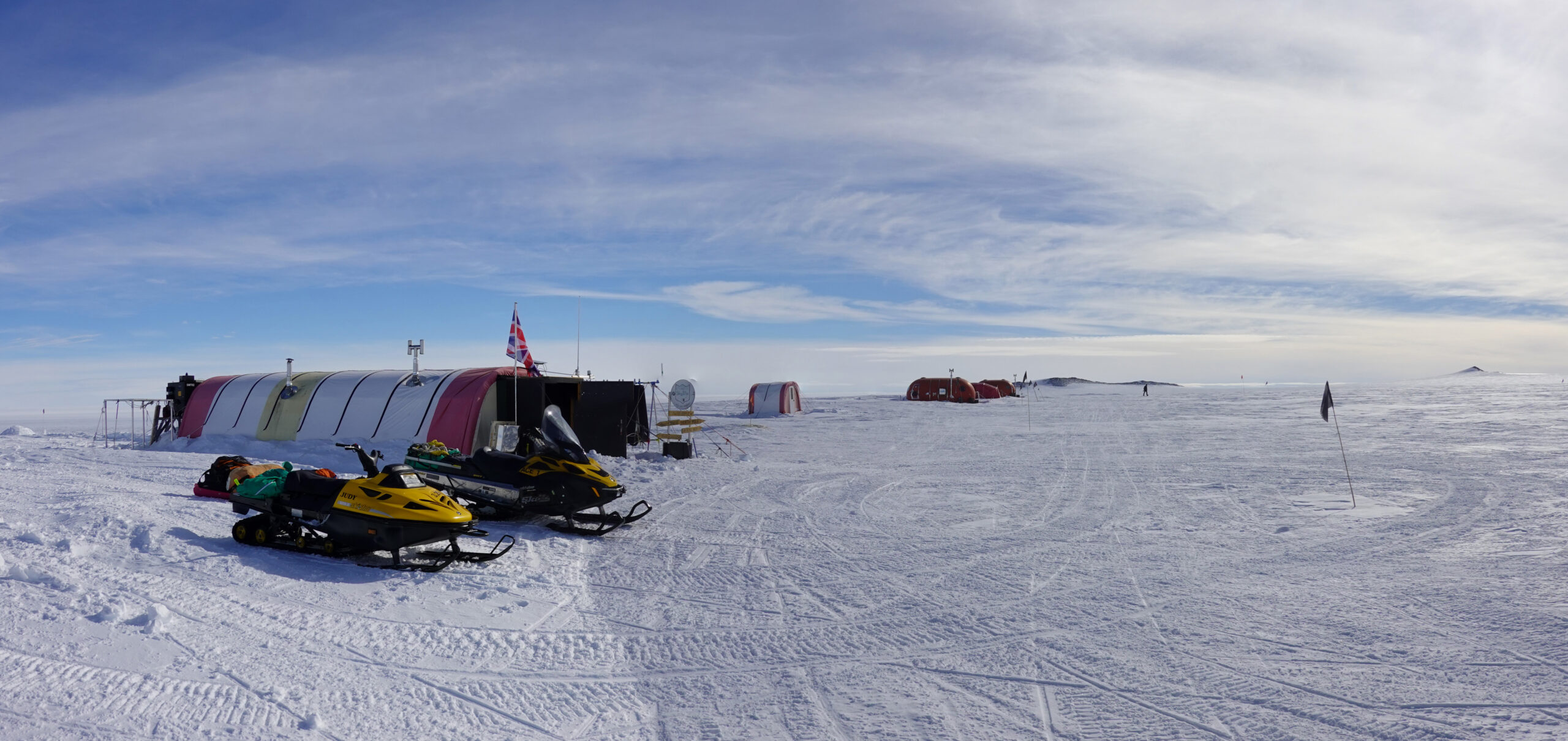 A snowy field camp with skidoos and tents