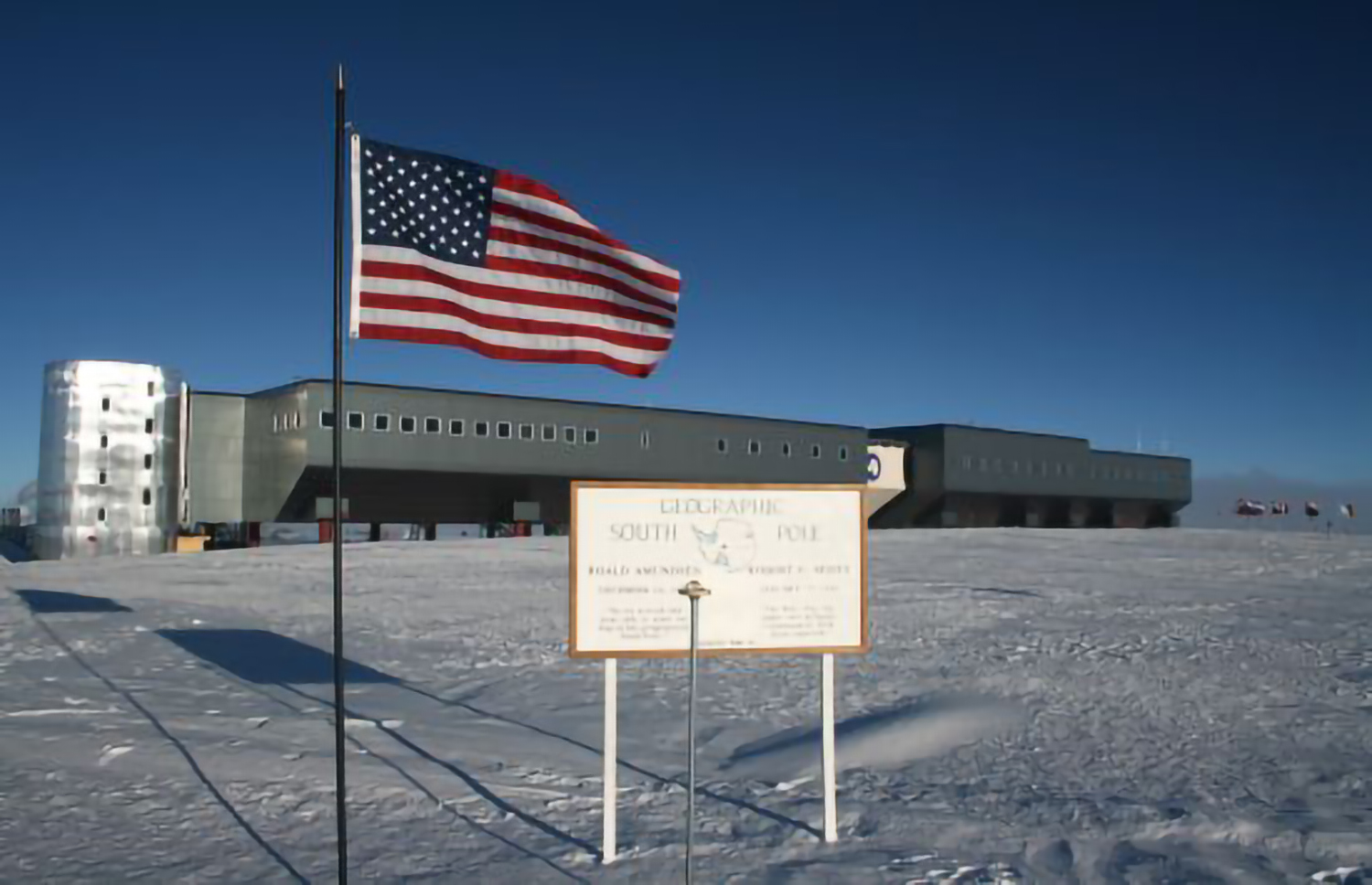 USA flag next to a sign saying South Pole