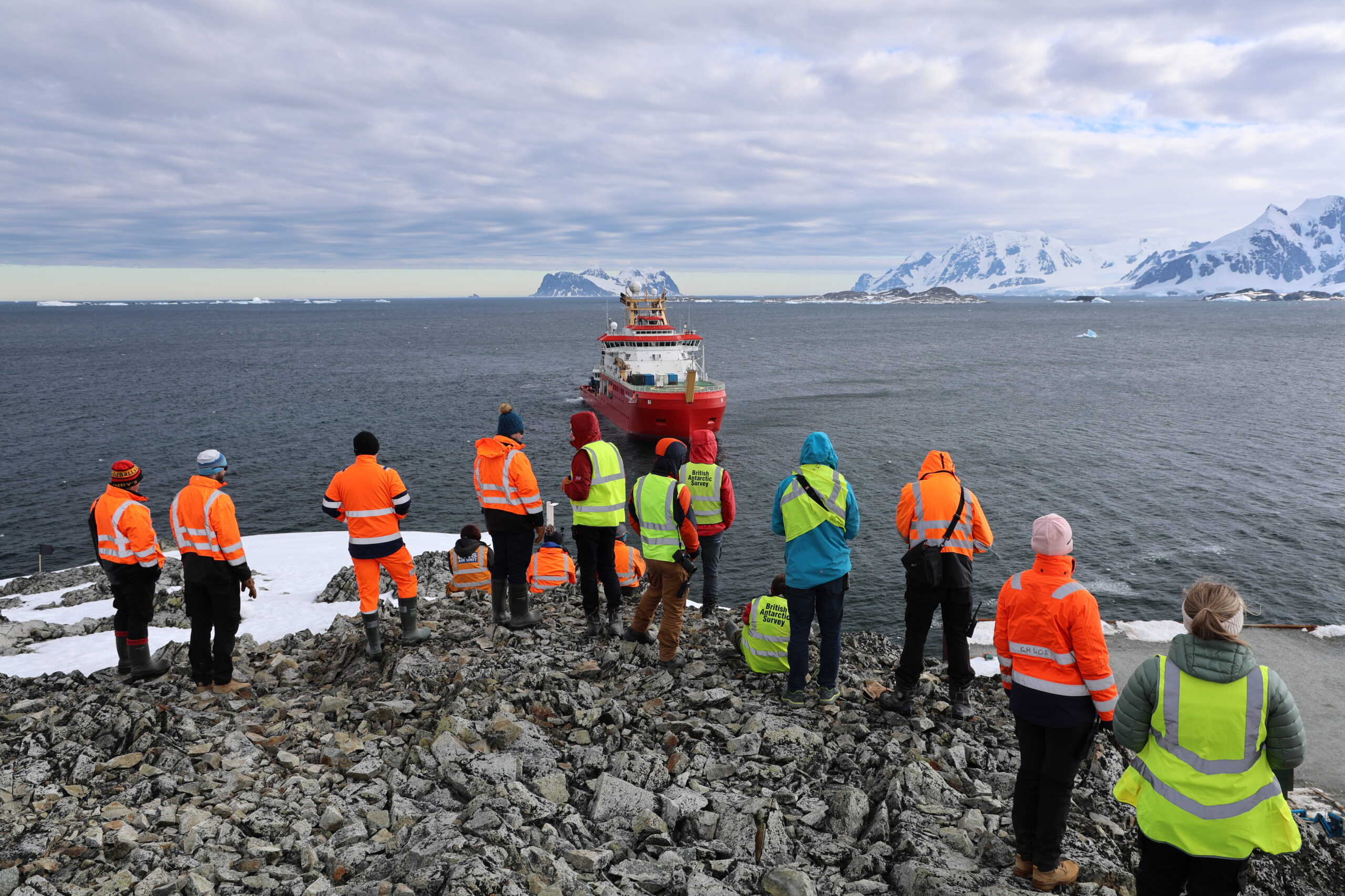 A group of people watching a ship coming in